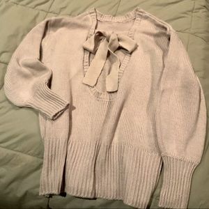 Blush colored women’s sweater with open back